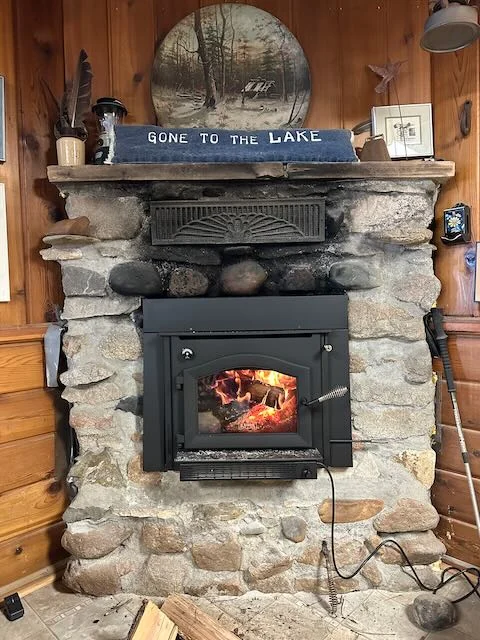 Wood-burning insert set in the cabin's original stone fireplace