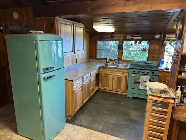 Remodeled cabin kitchen with retro turquoise refrigerator and range