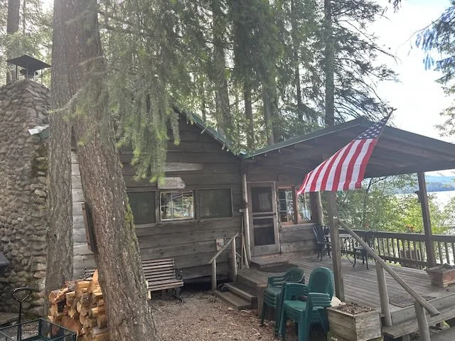 Historic cedar cabin with covered deck and American flag