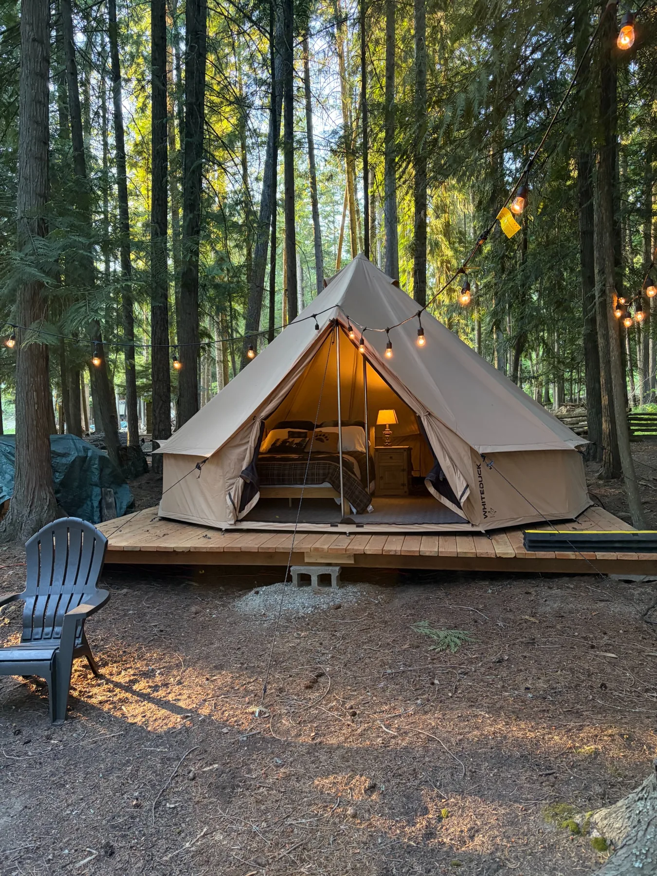 Exterior of the canvas tent on its wooded platform under string lights